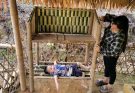 Single mother – making a dish rack out of bamboo.